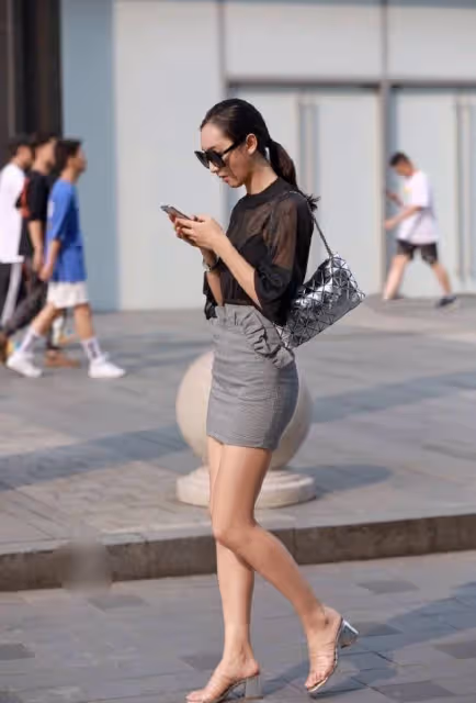 包臀裙小姐姐走在大街上，享受著靜謐的夏季時光