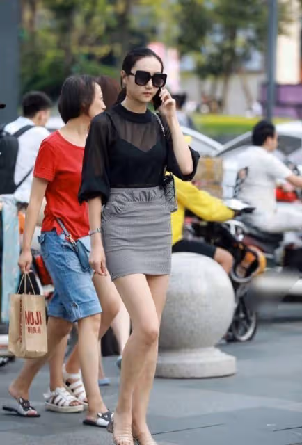 包臀裙小姐姐走在大街上，享受著靜謐的夏季時光