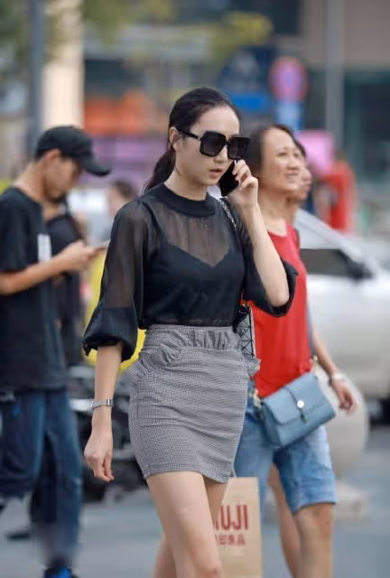 包臀裙小姐姐走在大街上，享受著靜謐的夏季時光