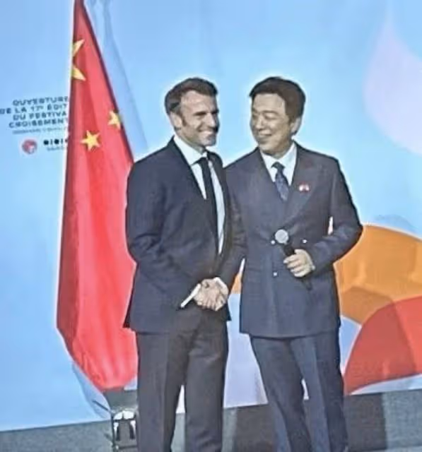 57歲鞏俐陪法國總統訪華，嘉賓爭相與之合影，老公米歇爾被冷落