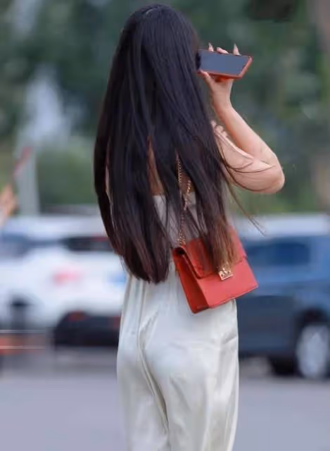 美女一身凈白弔帶連衣裙，微風吹拂下裙擺飛揚，美不勝收