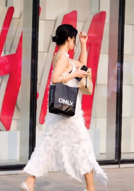 路人街拍，小姐姐身穿一件白色的弔帶連衣裙，很有仙女氣