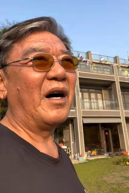 李立群家屋頂上掛紅旗，大門貼中國春聯，表示自己對祖國忠心耿耿