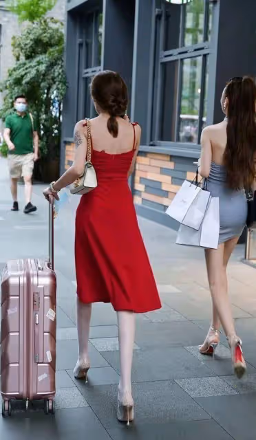 美女一襲紅色弔帶連衣長裙，展示出自己與眾不同的魅力