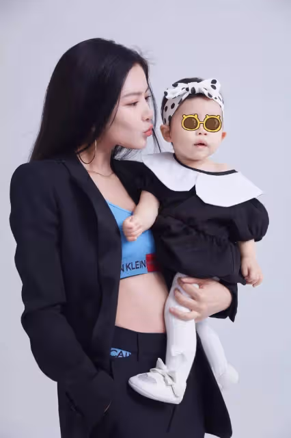 王燦攜女兒小蛋餃出境，黑色西裝內搭藍色短褲背心，顯現好身材