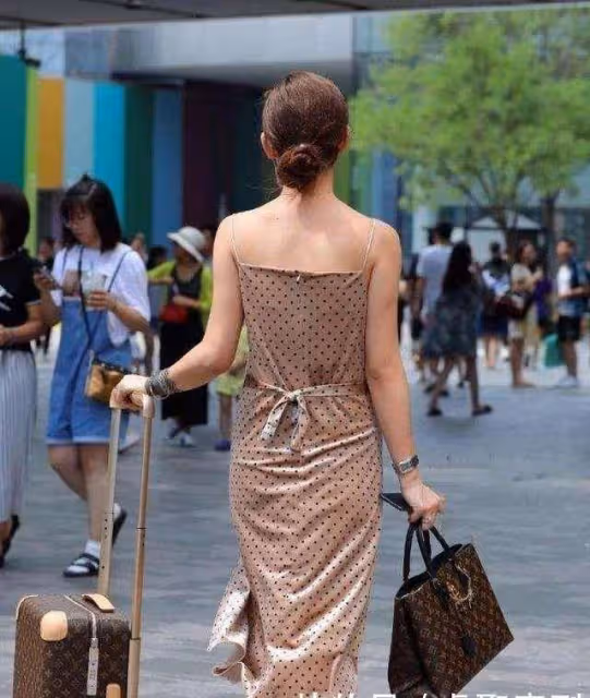粉色冰絲弔帶搭配闊腿褲，清風吹過涼爽又性感，展現完美身材