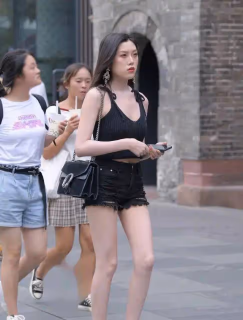 緊身牛仔褲配黑色小背心，同色系穿搭很顯瘦，小姐姐膚白貌美很贊