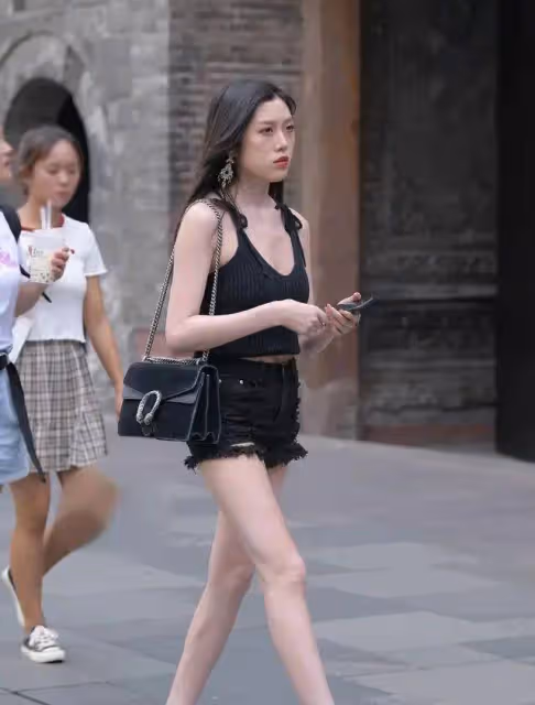 緊身牛仔褲配黑色小背心，同色系穿搭很顯瘦，小姐姐膚白貌美很贊