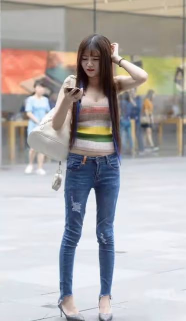 穿緊身牛仔褲打造性感身材，撓頭的樣子好可愛，彩虹色上衣很俏皮