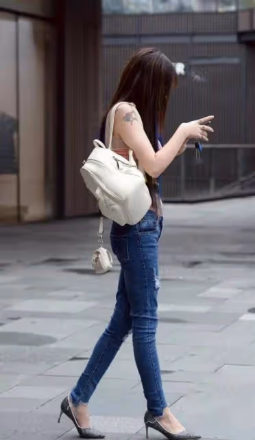 穿緊身牛仔褲打造性感身材，撓頭的樣子好可愛，彩虹色上衣很俏皮