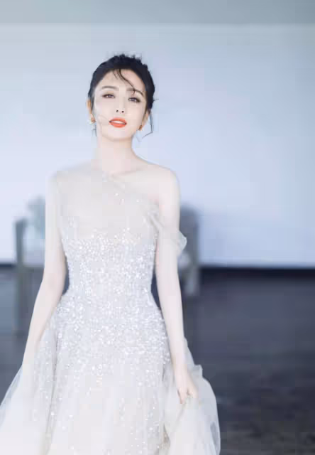 佟麗婭海邊漫步,身穿銀色閃亮紗裙顯曼妙身姿,如銀河飄落的仙女