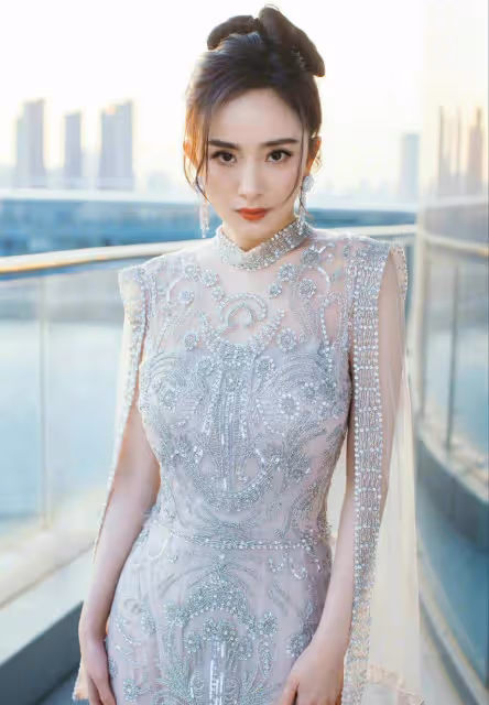 佟麗婭海邊漫步，身穿銀色閃亮紗裙顯曼妙身姿，如銀河飄落的仙女