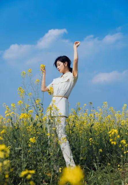 萬茜一身白色套裝清新優雅,油菜花田裡曼妙生姿,盡顯春日美好