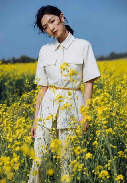 萬茜一身白色套裝清新優雅,油菜花田裡曼妙生姿,盡顯春日美好