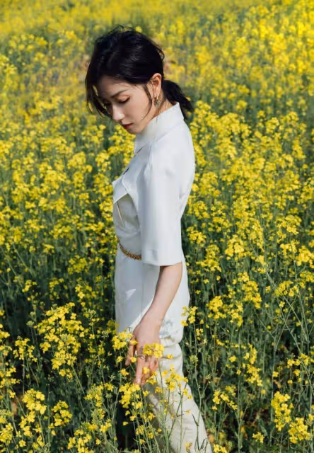 萬茜一身白色套裝清新優雅,油菜花田裡曼妙生姿,盡顯春日美好