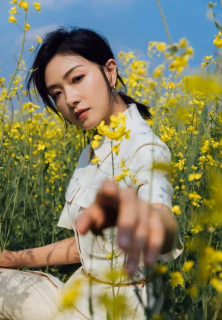 萬茜一身白色套裝清新優雅,油菜花田裡曼妙生姿,盡顯春日美好