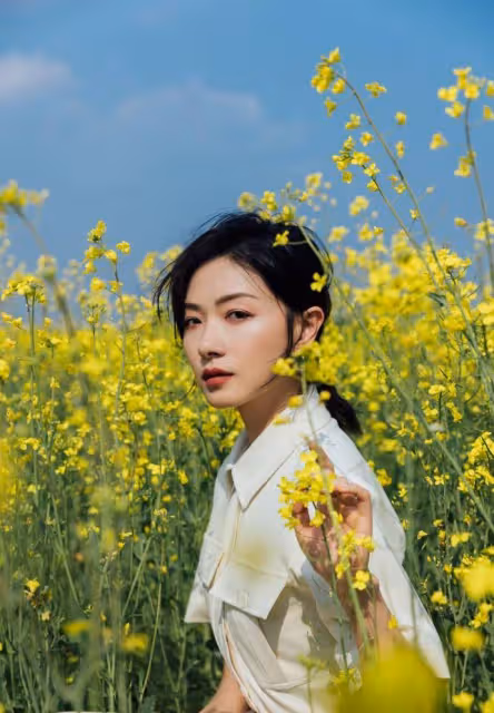 萬茜一身白色套裝清新優雅,油菜花田裡曼妙生姿,盡顯春日美好