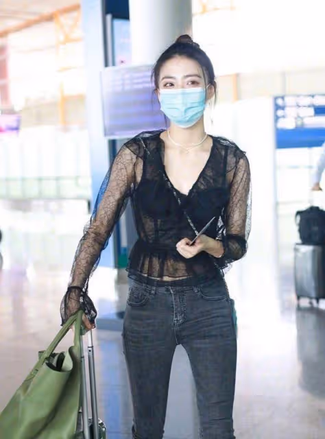身穿黑色時尚上衣女人味十足,緊身牛仔褲凸顯曼妙身材,太魅惑