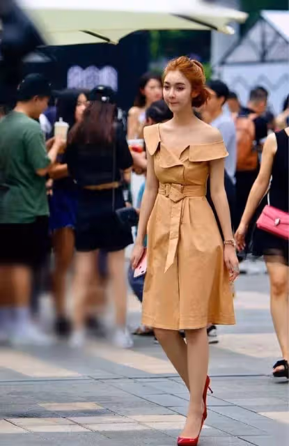 淡黃色的露肩連衣裙，收腰的款式，展示出女子那曼妙的腰線