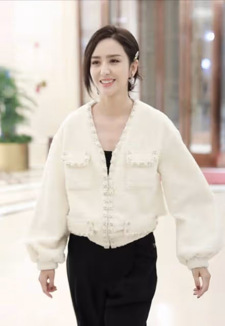 佟麗婭私服很有亮點,白色香風外套配黑色連體裝,造型時尚簡約