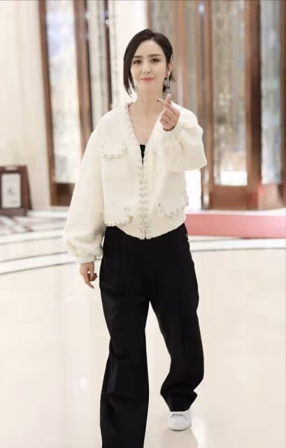佟麗婭私服很有亮點,白色香風外套配黑色連體裝,造型時尚簡約