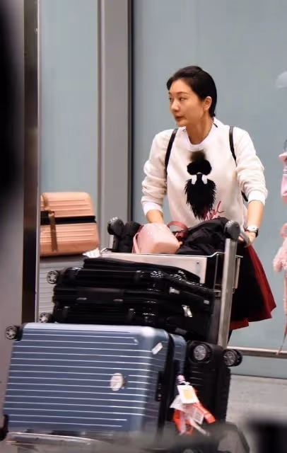 張藝謀女子挺嬌美的,白色衛衣配紅色短裙,看不出是40多歲的人