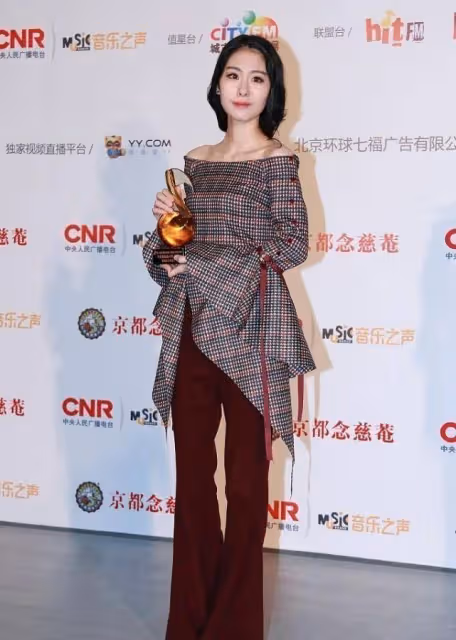 張碧晨的穿著略顯老氣,雖然露臍裝秀出了小蠻腰,但不咋顯美