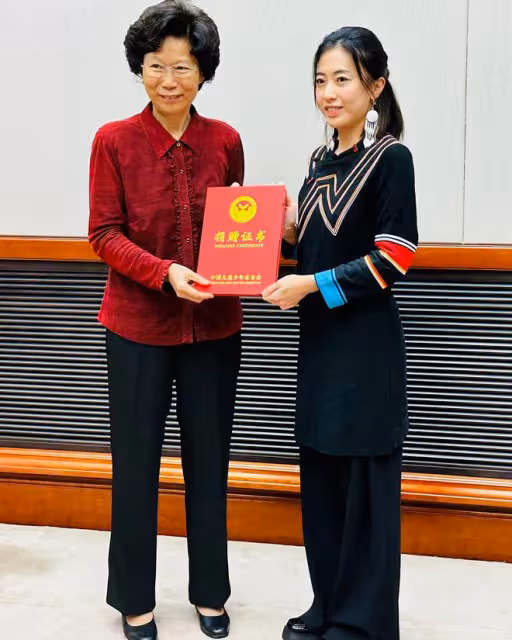 甘比和女兒劉秀樺向大涼山捐款1800萬,穿上彝族衣服接受頒獎