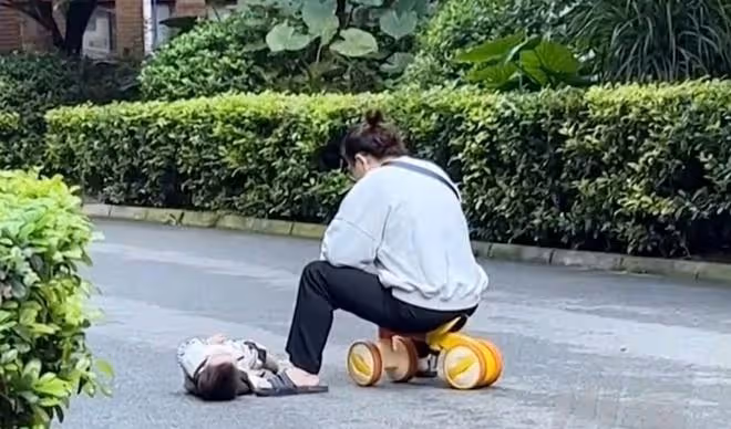 萌娃躺地上哭鬧,媽媽坐在扭扭車上刷手機,兩名小朋友在線吃瓜