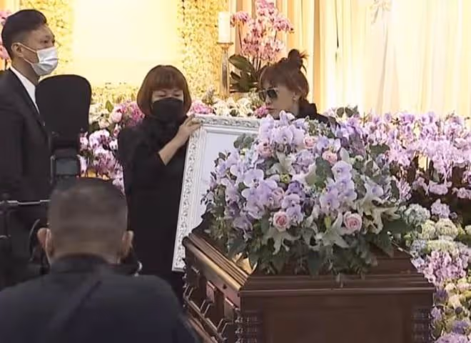 李玟遺體運往火葬場,二姐手捧遺照不願離去,眾親友含淚送別