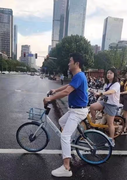 吳京街頭騎自行車趕活動,找路人問路接地氣,快到粉絲都追不上