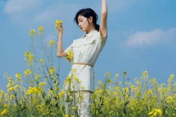 萬茜一身白色套裝清新優雅,油菜花田裡曼妙生姿,盡顯春日美好