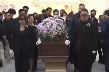 李玟遺體運往火葬場,二姐手捧遺照不願離去,眾親友含淚送別
