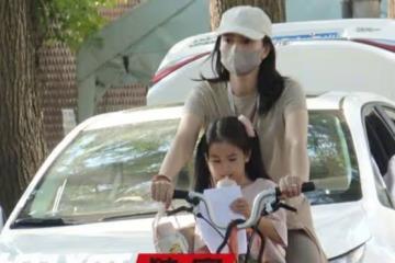 高圓圓騎單車接女兒放學,卡其色短袖長裙搭配棕色瑜伽褲,休閒美