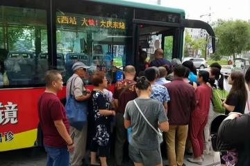 早高峰公交車前擠滿老年人，年輕人等著去上班，被擠在外圍干著急